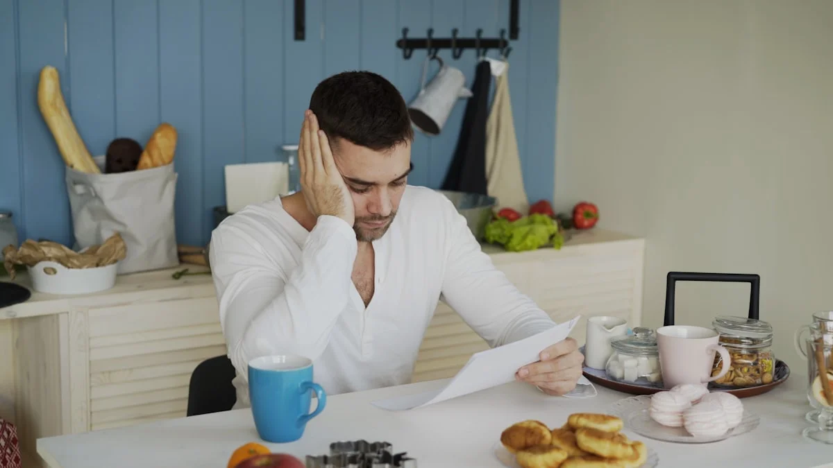 Hombre leyendo una factura vencida en la mesa de su cocina temprano en la mañana, hipoteca de New Jersey